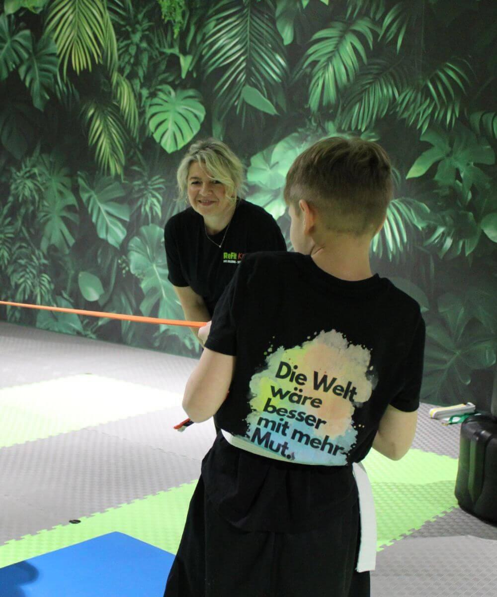 Training mit Coach — Kind übt mit Widerstandsband